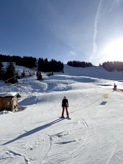Verschneite Pisten und Bergpanorama im Reit im Winkl Skigebiet an einem sonnigen Wintertag.